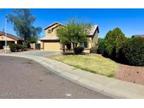 Charming two-story home with a manicured lawn, mature trees, and a two car garage at 2634 S 63Rd Dr, Phoenix, AZ 85043