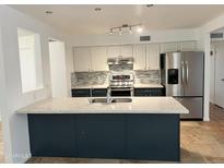Charming kitchen with granite island, stainless steel appliances, and decorative tile backsplash at 2838 E Contessa St, Mesa, AZ 85213