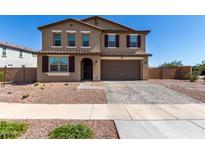 Beautiful two-story home featuring a desert landscape, brick driveway and a two car garage at 40213 W James Ln, Maricopa, AZ 85138