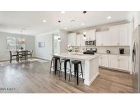 Open kitchen featuring an island with bar seating, stainless steel appliances and a dining area in a spacious layout at 4360 N 186Th Ln, Goodyear, AZ 85395