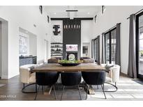Open-concept dining area features a large wooden table, modern chairs, and an elegant lighting fixture at 5929 E Indian School Rd, Phoenix, AZ 85018