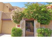 Charming condo entrance with vibrant flowering bushes, offering a welcoming and picturesque curb appeal at 7021 E Earll Dr # 204, Scottsdale, AZ 85251