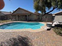 Sparkling pool surrounded by a brick patio and mature landscaping, perfect for outdoor relaxation at 7813 E Covina St, Mesa, AZ 85207