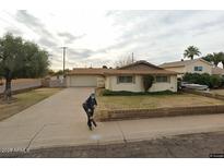 Charming single-story home featuring a manicured front yard and a convenient two-car garage at 8749 E Keim E Dr, Scottsdale, AZ 85250