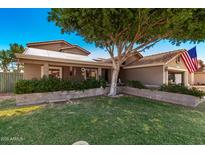 Charming single-story home with a landscaped front yard, solar panels, and an American flag at 937 N Marble St, Gilbert, AZ 85234