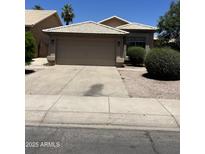 Single-Gathering home showcasing a tiled roof, manicured bushes, and a two-car garage at 1040 W Juniper Ave, Gilbert, AZ 85233