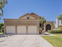Spacious home with a three-car garage, mature landscaping, and a well-manicured lawn for great curb appeal at 13064 N 100Th Pl, Scottsdale, AZ 85260