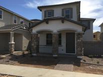 Charming two-story home with a stone column porch, manicured landscaping, and an inviting entrance with house number 13465 at 13498 N 156Th Dr, Surprise, AZ 85379