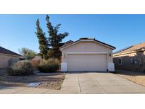 Charming single-level home with a two-car garage, desert landscaping, and tile roof at 15364 W Acapulco Ln, Surprise, AZ 85379