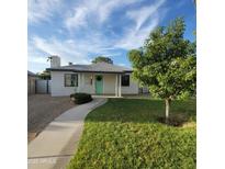 Charming exterior features a white brick facade, well-manicured lawn, and inviting turquoise front door at 2246 E Yale St, Phoenix, AZ 85006