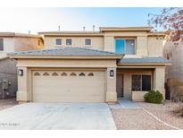 Two-story home with a two-car garage, desert landscaping, and neutral colored stucco at 22500 N Greenland Park Dr, Maricopa, AZ 85139