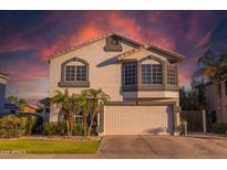 Charming two-story home with desert landscaping, an attached two-car garage, and a colorful sunset sky at 7463 E Monte Ave, Mesa, AZ 85209