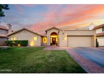 Charming single-Gathering home boasts well-manicured lawn, archway entrance, and attached two car garage at 8875 S Ash Ave, Tempe, AZ 85284