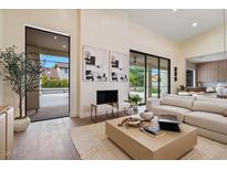 Bright living room with modern fireplace, sleek furniture, and access to an outdoor space at 9820 N 87Th Pl, Scottsdale, AZ 85258