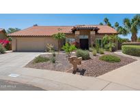 Charming single-story home featuring well-manicured desert landscaping, a red tile roof, and a two-car garage at 10450 E Terra Dr, Scottsdale, AZ 85258