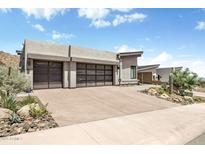 Contemporary home featuring desert landscaping and two-car garage with glass panel doors at 14507 N Valencia Dr, Fountain Hills, AZ 85268
