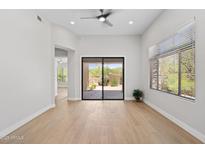 Bright living room featuring hardwood floors, neutral walls, and sliding glass doors to the outdoor space at 19550 N Grayhawk Dr # 1144, Scottsdale, AZ 85255
