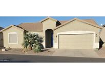Charming single-story home with a desert landscape, a light-colored exterior, and an attached two-car garage at 2101 S Meridian Rd # 437, Apache Junction, AZ 85120