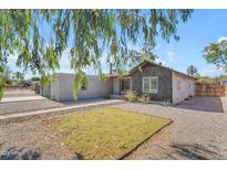 Charming single-story home featuring a mix of stucco and shingle siding, complemented by a gravel yard and fresh lawn at 2215 W Highland Ave, Phoenix, AZ 85015