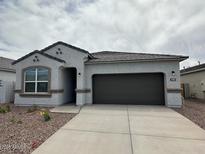 Charming single-story home features a neutral color palette, a covered entryway, and a two-car garage at 25183 N 183Rd Dr, Wittmann, AZ 85361