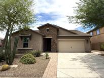 Charming single-story home featuring a stone facade, two-car garage, and desert landscaping at 3721 W Aracely Dr, New River, AZ 85087