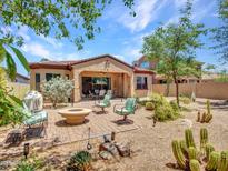 Inviting backyard featuring a fire pit, ample seating, and desert landscaping, perfect for outdoor entertaining at 43510 N 44Th Ave, New River, AZ 85087