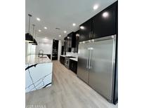 Spacious kitchen with modern stainless steel appliances, an island with white marble countertops, and sleek black cabinets at 5088 S Ponderosa Dr, Gilbert, AZ 85298