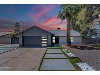 Charming home featuring modern garage door, pathway lighting, and well-manicured landscaping at 5239 E Waltann Ln, Scottsdale, AZ 85254