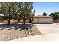 Charming single-story home featuring desert landscaping, a spacious driveway, and a two-car garage at 7315 W Monte Lindo Ln, Glendale, AZ 85310
