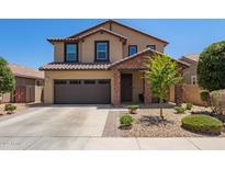Inviting two-story home featuring a neutral color scheme, stone accents, and a two-car garage at 7641 W Whitehorn Trl, Peoria, AZ 85383