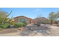 Single story desert home boasts xeriscaping, gravel and mature cacti and desert plants at 8687 W Bajada Rd, Peoria, AZ 85383