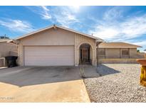Charming single-story home with a brick facade, desert landscaping, and a two-car garage at 940 S Revere --, Mesa, AZ 85210