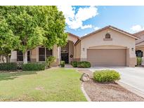 Inviting single-story home featuring a neutral stucco facade, mature landscaping, and a two-car garage at 1161 N Cole Dr, Gilbert, AZ 85234