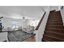 Bright living room with plush seating, hardwood floors, and a striking black and white rug near wood stairs at 15415 N 2Nd Way, Phoenix, AZ 85022