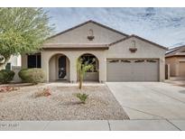 Charming single-story home with arched entryway, two-car garage, and low maintenance desert landscaping at 17562 W Agave Ct, Goodyear, AZ 85338