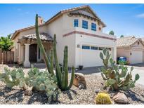 Two-story home featuring a stucco exterior, tile roof, desert landscaping, and an attached two-car garage at 18031 N 12Th Pl, Phoenix, AZ 85022