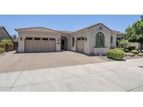 Charming single-story home with a tile roof, three-car garage, and meticulously landscaped front yard at 22255 E Quintero Rd, Queen Creek, AZ 85142