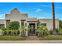 Stunning home featuring an ornamental gate, lush landscaping, and a meticulously manicured lawn at 3109 E Sierra Madre Way, Phoenix, AZ 85016