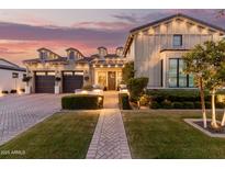 Inviting front exterior featuring manicured landscaping, brick walkway, and a charming facade at sunset at 3684 E Boot Track Trl, Gilbert, AZ 85296