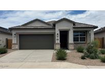 Charming single-story home features a two-car garage, desert landscaping, and modern architectural details at 40070 W Venture Rd, Maricopa, AZ 85138