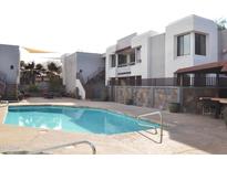 Resort style community pool with mature landscape, stairs to upper level and an outdoor kitchen for entertaining at 4120 N 78Th St # 116, Scottsdale, AZ 85251