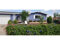 Charming blue home with a well-manicured, landscaped front yard and white lattice accents at 4626 W Altadena Ave, Glendale, AZ 85304