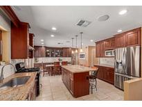 Spacious kitchen with an island, stainless steel appliances, granite countertops, and custom cabinetry at 6532 E Aster Dr, Scottsdale, AZ 85254