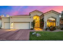 Charming home featuring a beautiful front yard, lush plants, and a two-car garage at 7439 E Beryl Ave, Scottsdale, AZ 85258