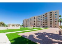 Low angle of modern apartment complex with green space and a pristine blue sky overhead at 7970 E Camelback Rd # 604, Scottsdale, AZ 85251