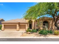 Inviting single-story home featuring a three-car garage and desert landscaping at 11324 E Diamond Cholla Dr, Scottsdale, AZ 85255