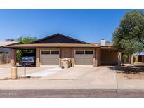 Charming single-story home featuring a brick facade, two-car garage, and mature landscaping at 13041 N 51St Dr, Glendale, AZ 85304