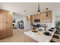 Modern kitchen featuring light wood cabinets, stainless appliances, quartz countertops and an island at 1720 W Behrend Dr, Phoenix, AZ 85027
