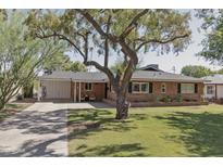 Charming brick home with mature tree, covered carport and inviting front porch at 1839 E Palo Verde Dr, Phoenix, AZ 85016