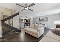Open-concept living area with modern stairs, ceiling fan, and view into kitchen and dining space at 3030 N Hayden Rd # 28, Scottsdale, AZ 85251